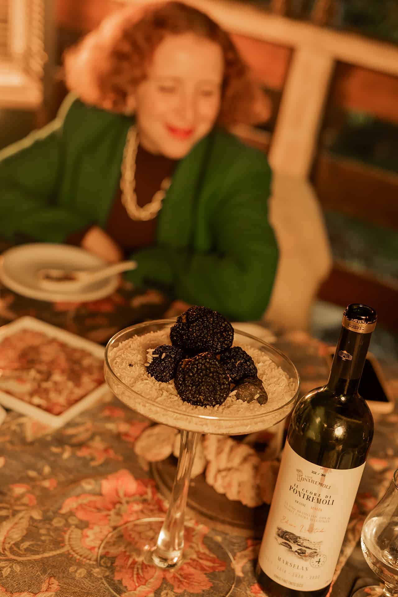Visitante à mesa com trufas e vinho