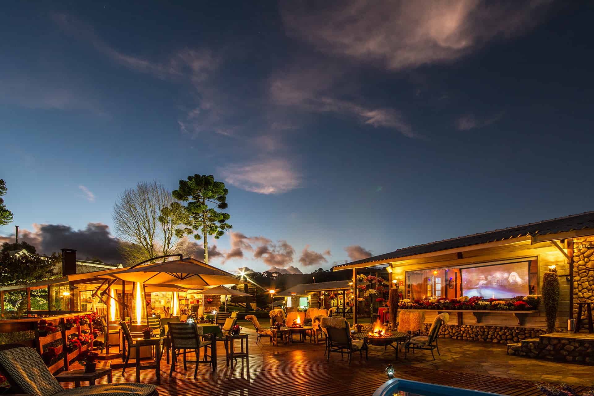 O deck e o restaurante iluminados sob o céu noturno